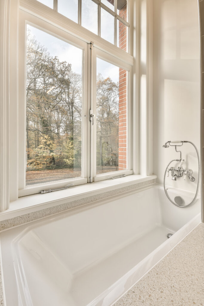 Bathroom with a bathtub and a small window in a modern house